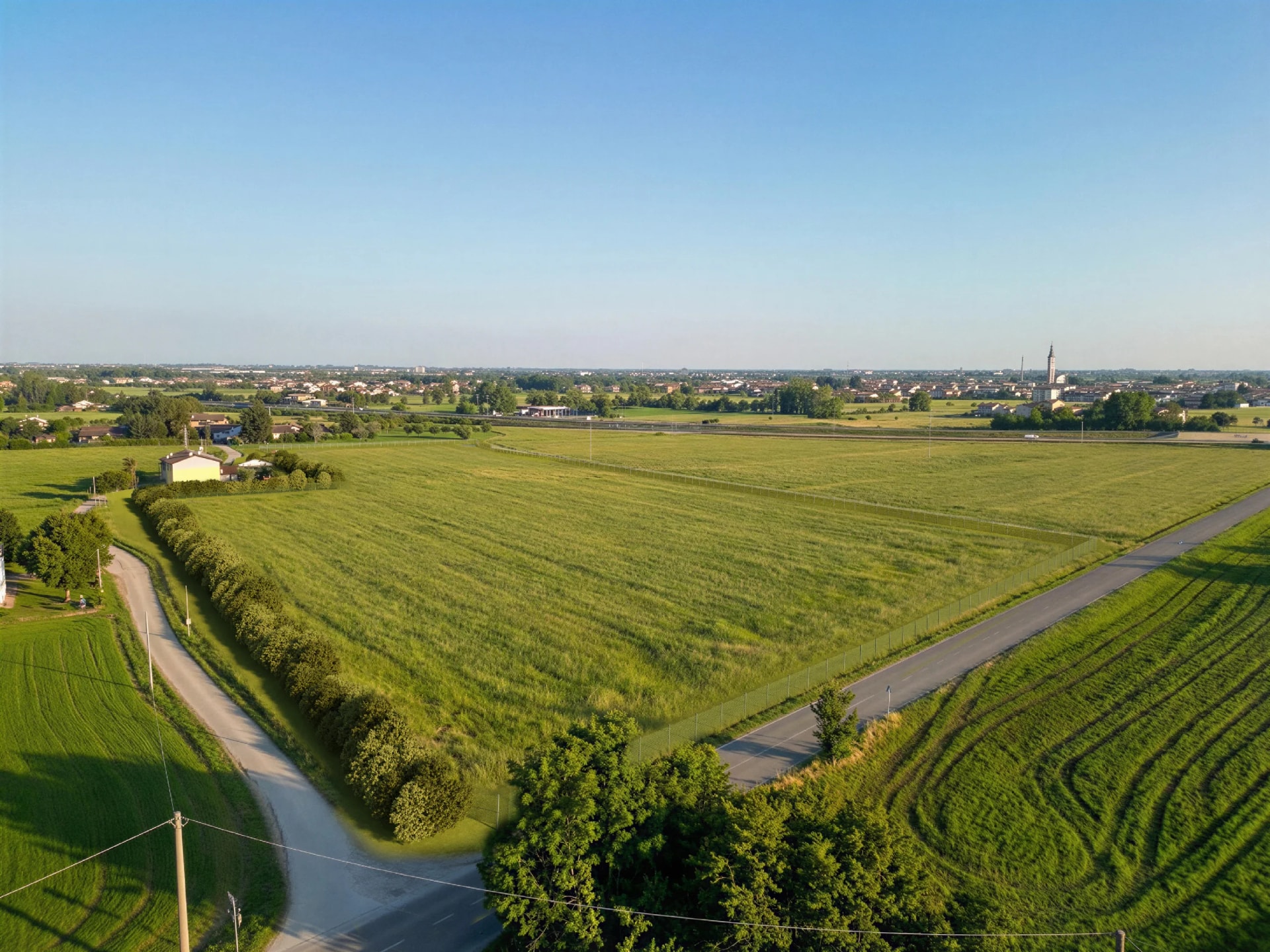 Luftaufnahme der Ackerfläche vor dem Eingriff, mit dem Ort im Hintergrund